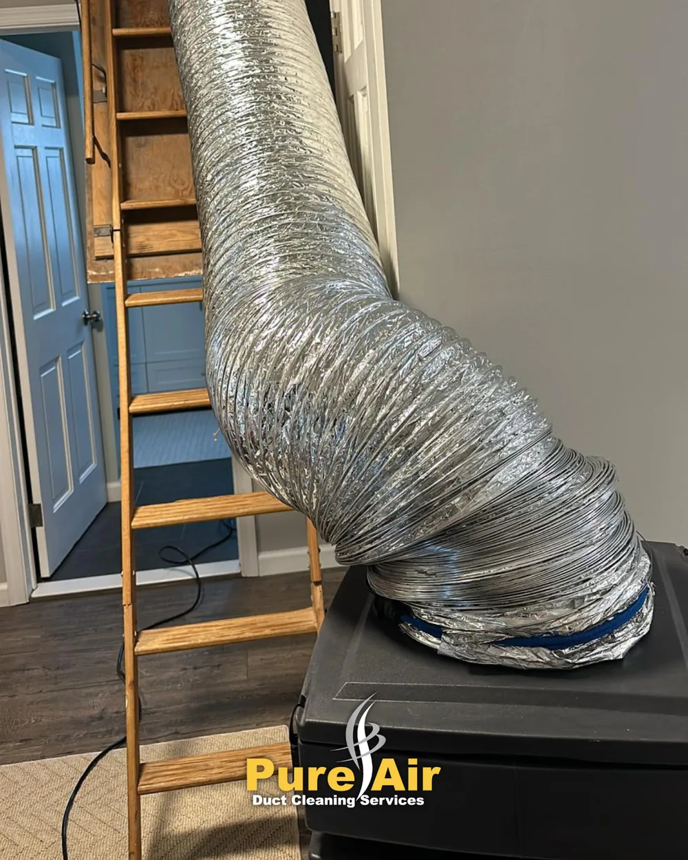 HEPA duct cleaning hose run up to a ceiling vent in a home